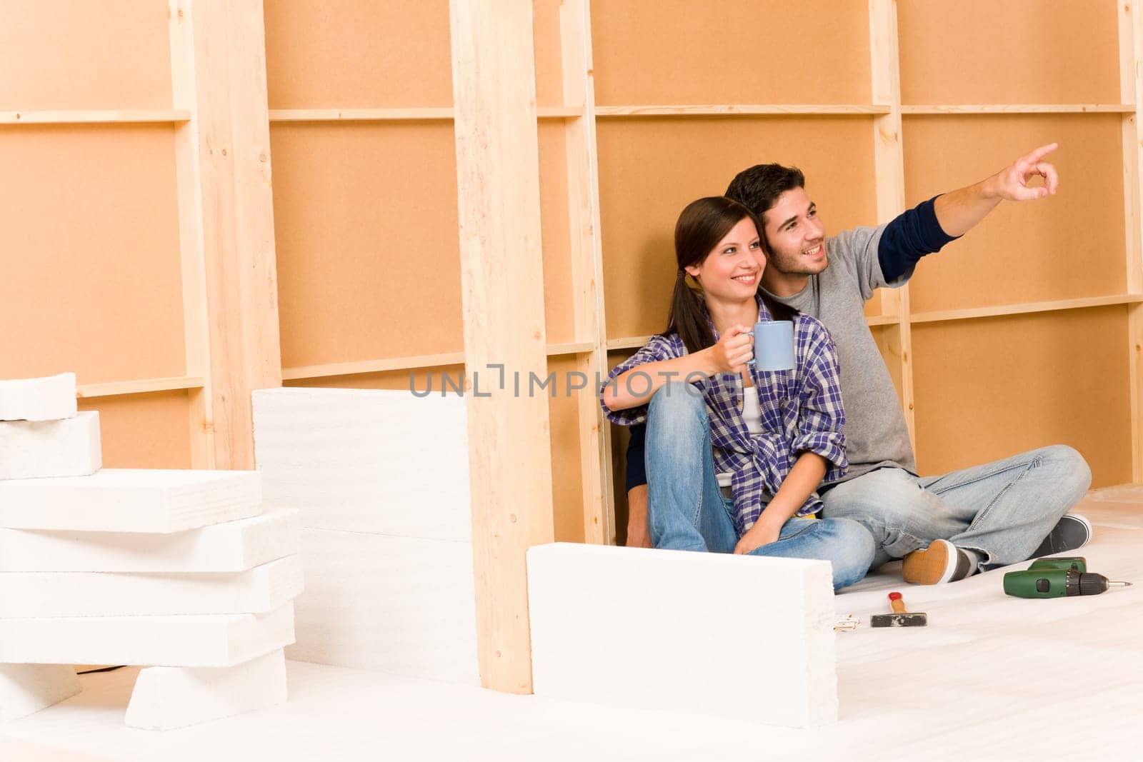 Home improvement smiling young couple relax on floor building wall