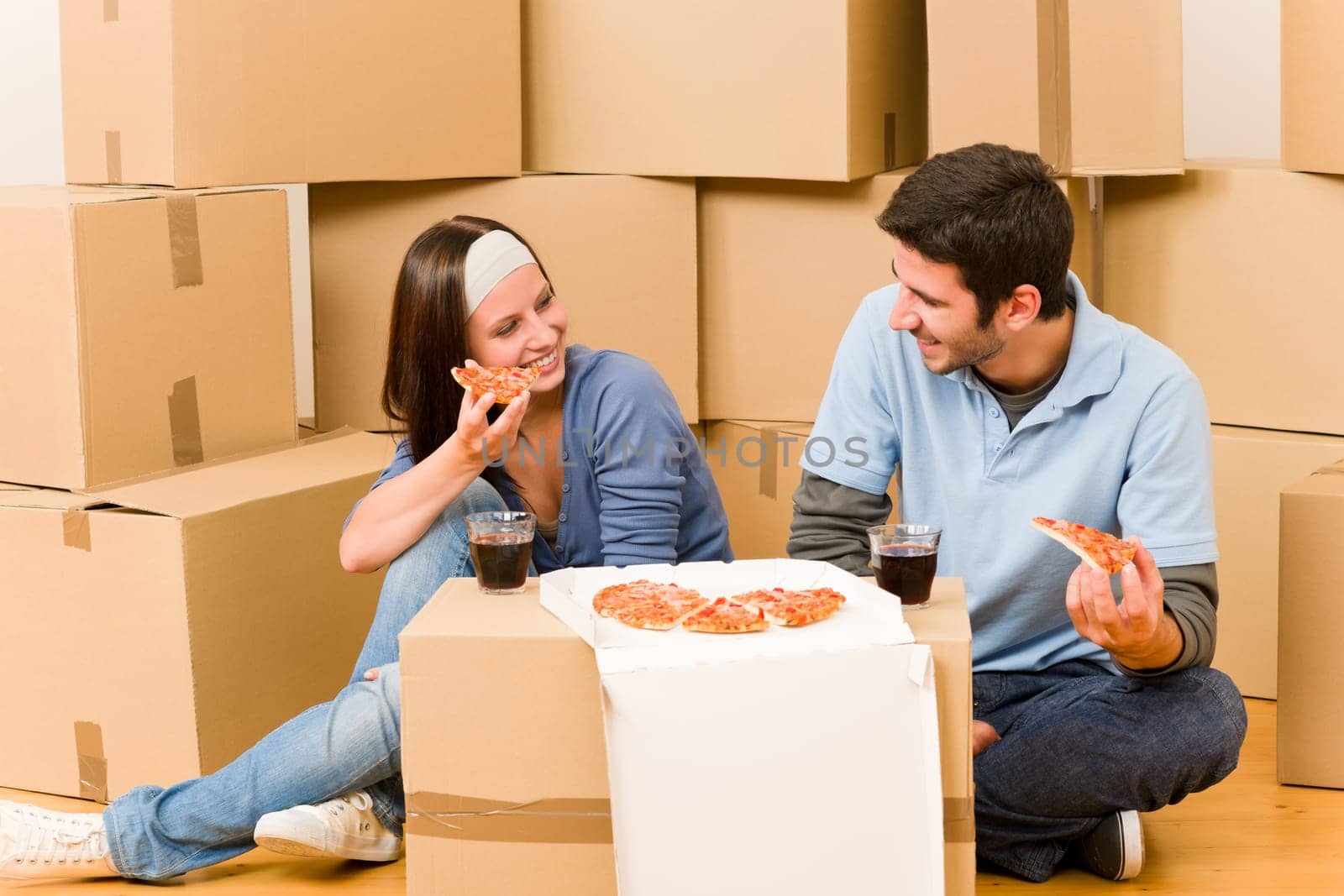 Moving into new home young happy couple eating pizza