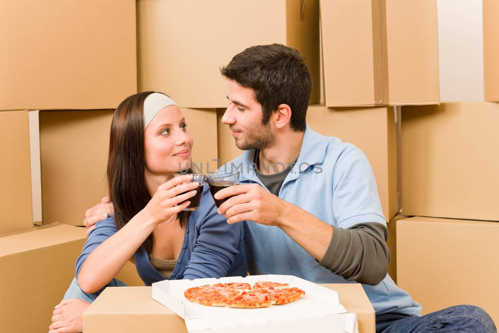 Moving into new home young happy couple have pizza lunch