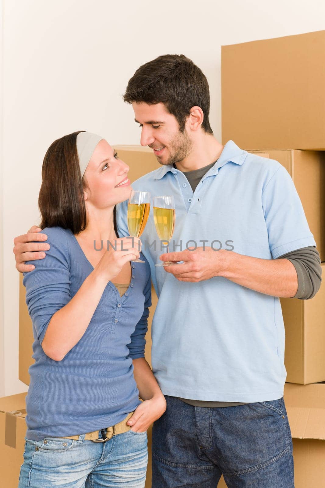Moving into new home young happy couple celebrating toast Champagne
