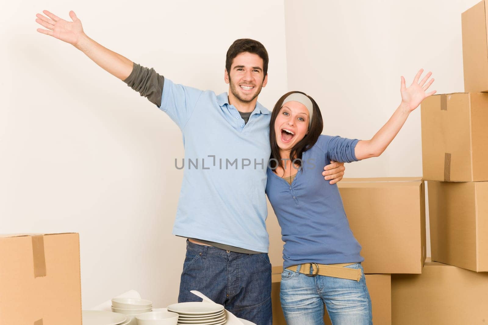 Moving new home young cheerful couple unpacking cardboard boxes together