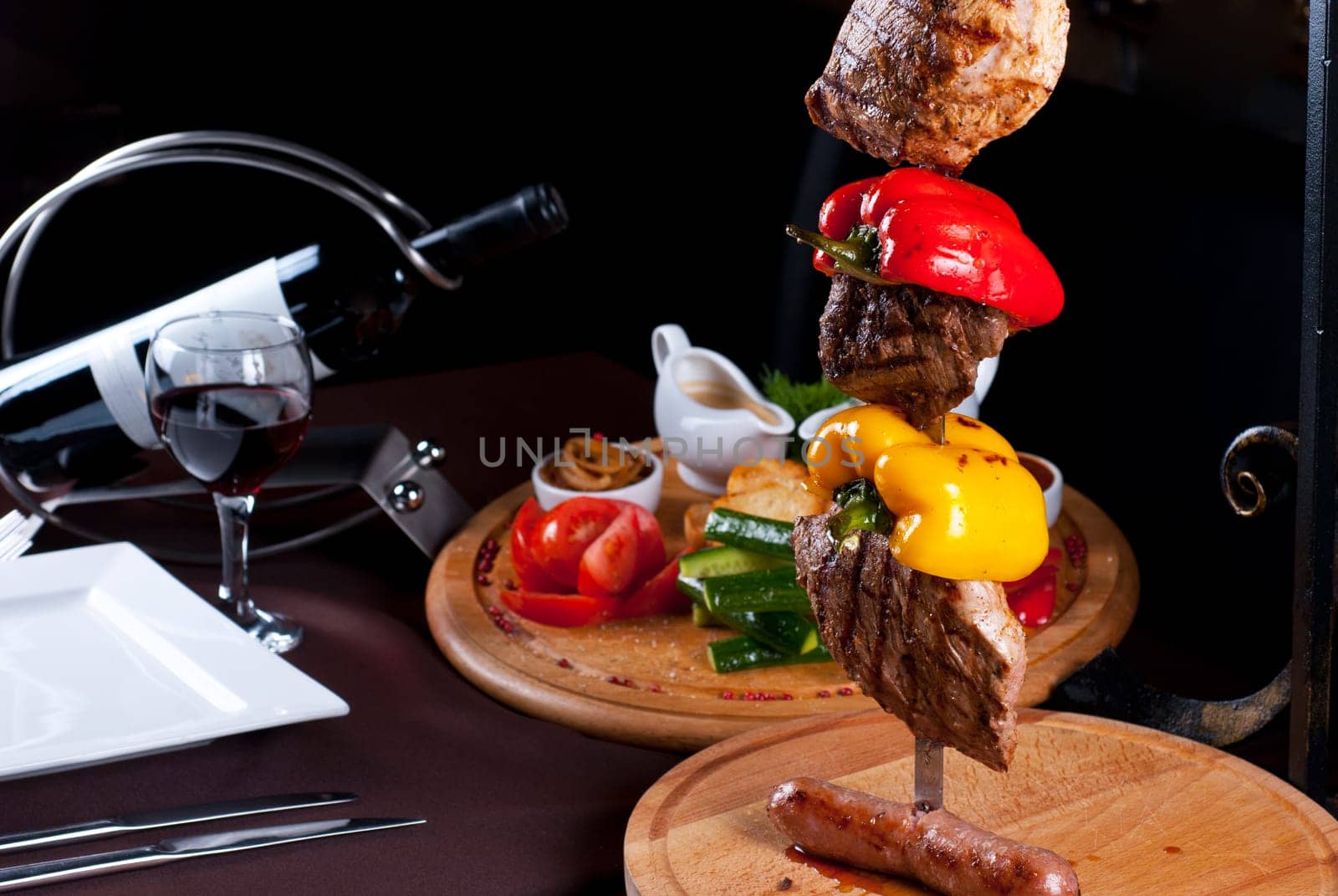 Big tasty roasted meat cuts at skewer on a decorated table