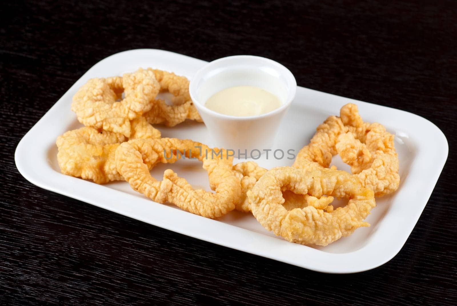 Deep-fried squid with sauce at white plate