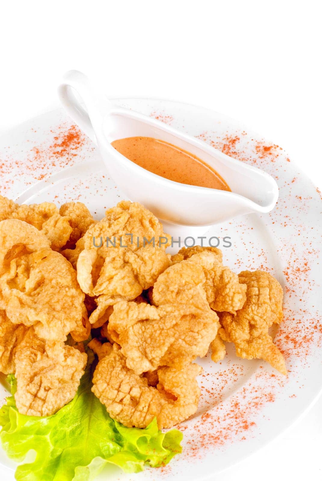 Deep-fried tiger shrimp with salad leaves, sauce closeup