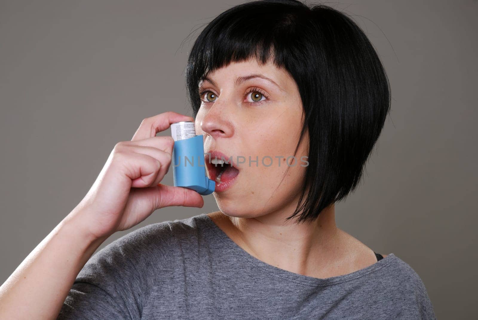 Young woman with asthma spray