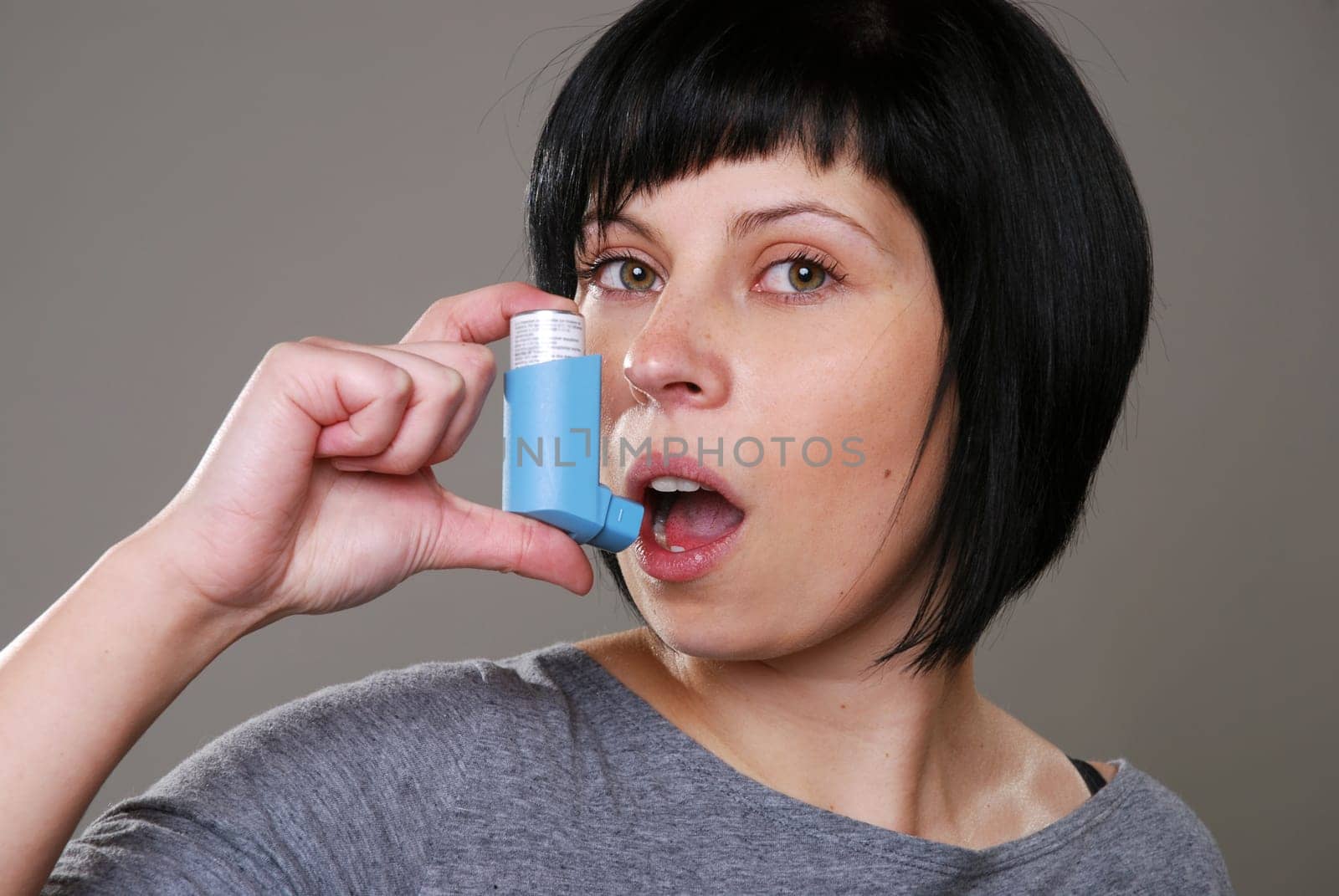 Young woman with asthma spray