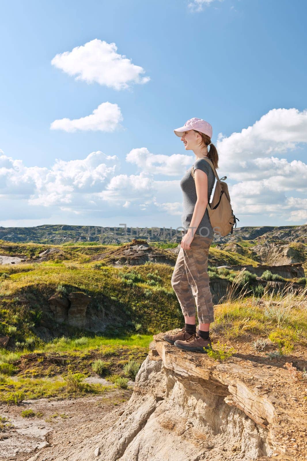 Happy female hiker looking onto the Badlands in Dinosaur provincial park, Alberta, Canada