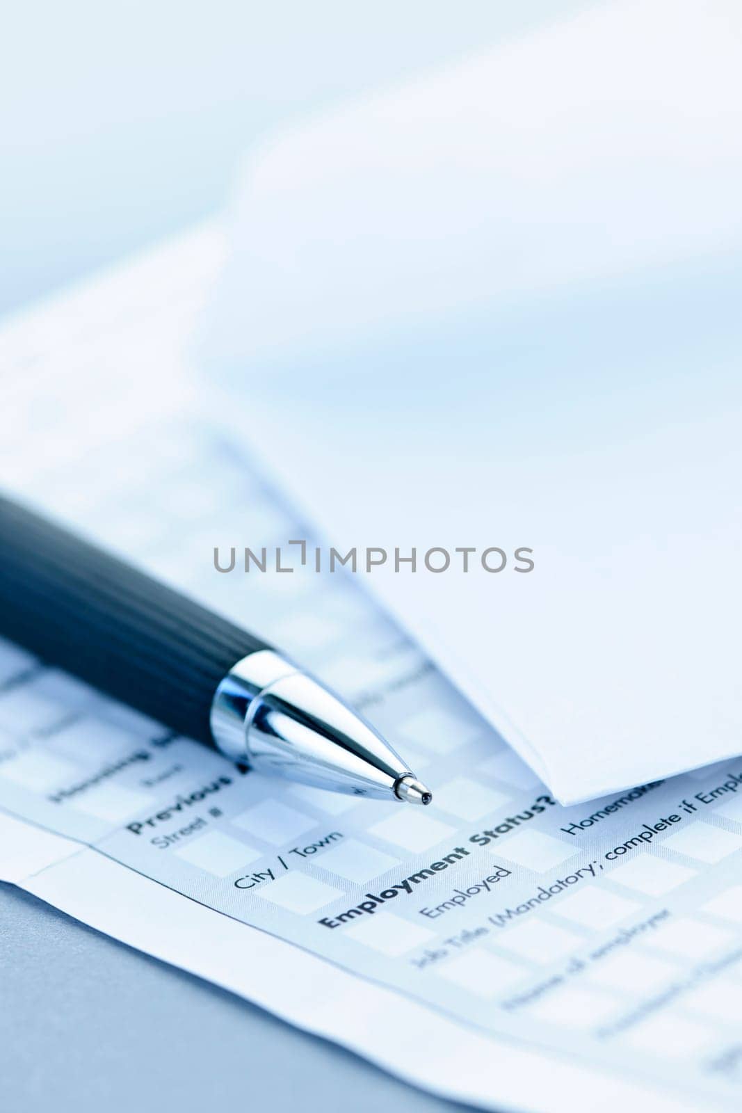 Blank credit application form with envelope and pen close up