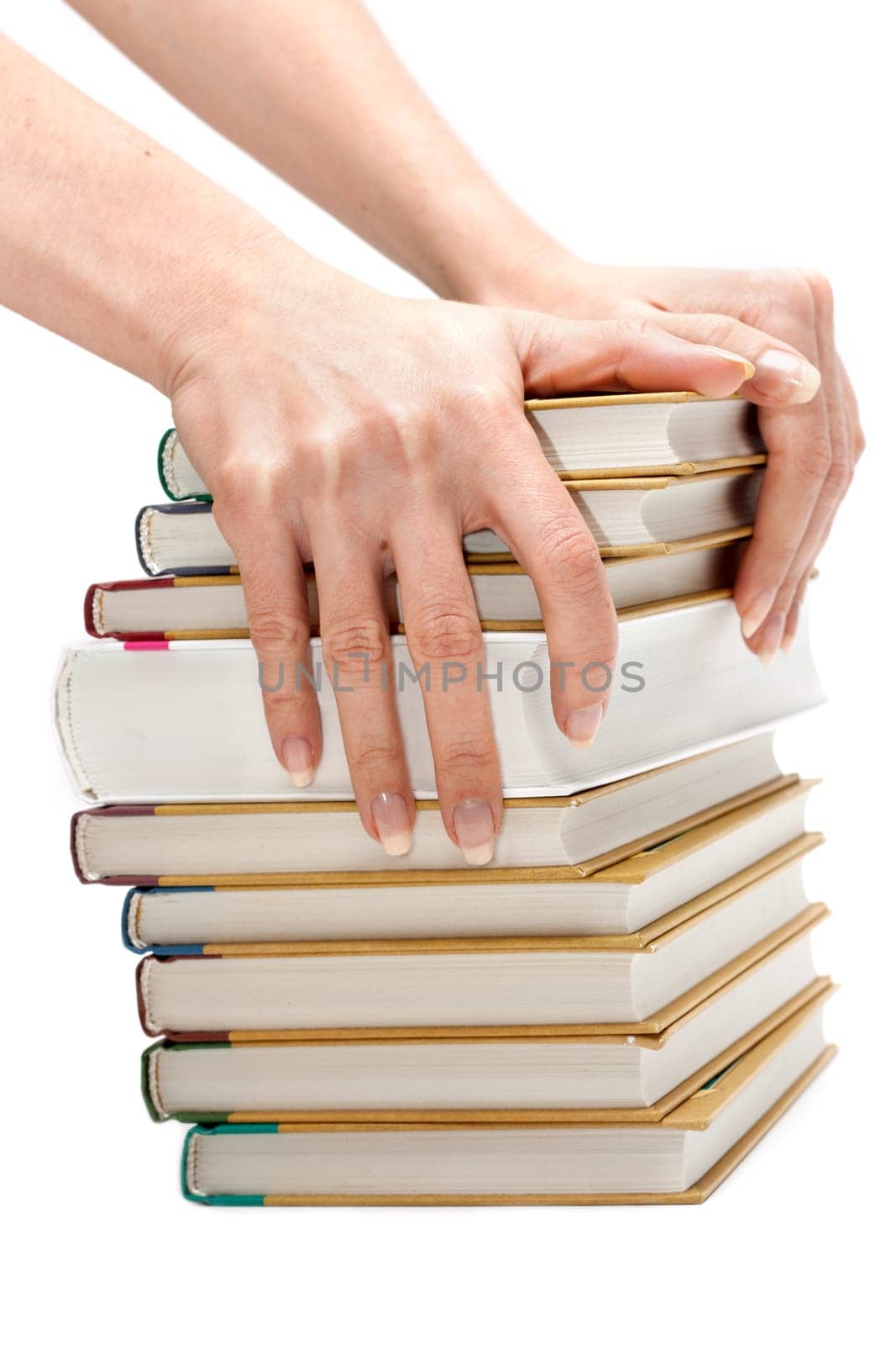 Feminine hands with manicure keeps pile of the books