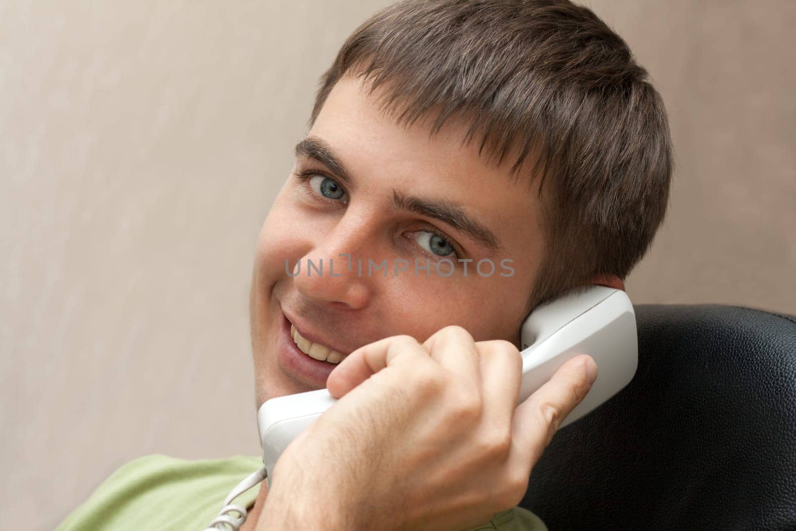 Man with telephone tube in hand smiles