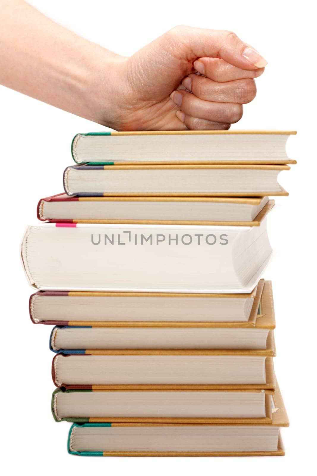 Feminine fist on pile of the books insulated on white background