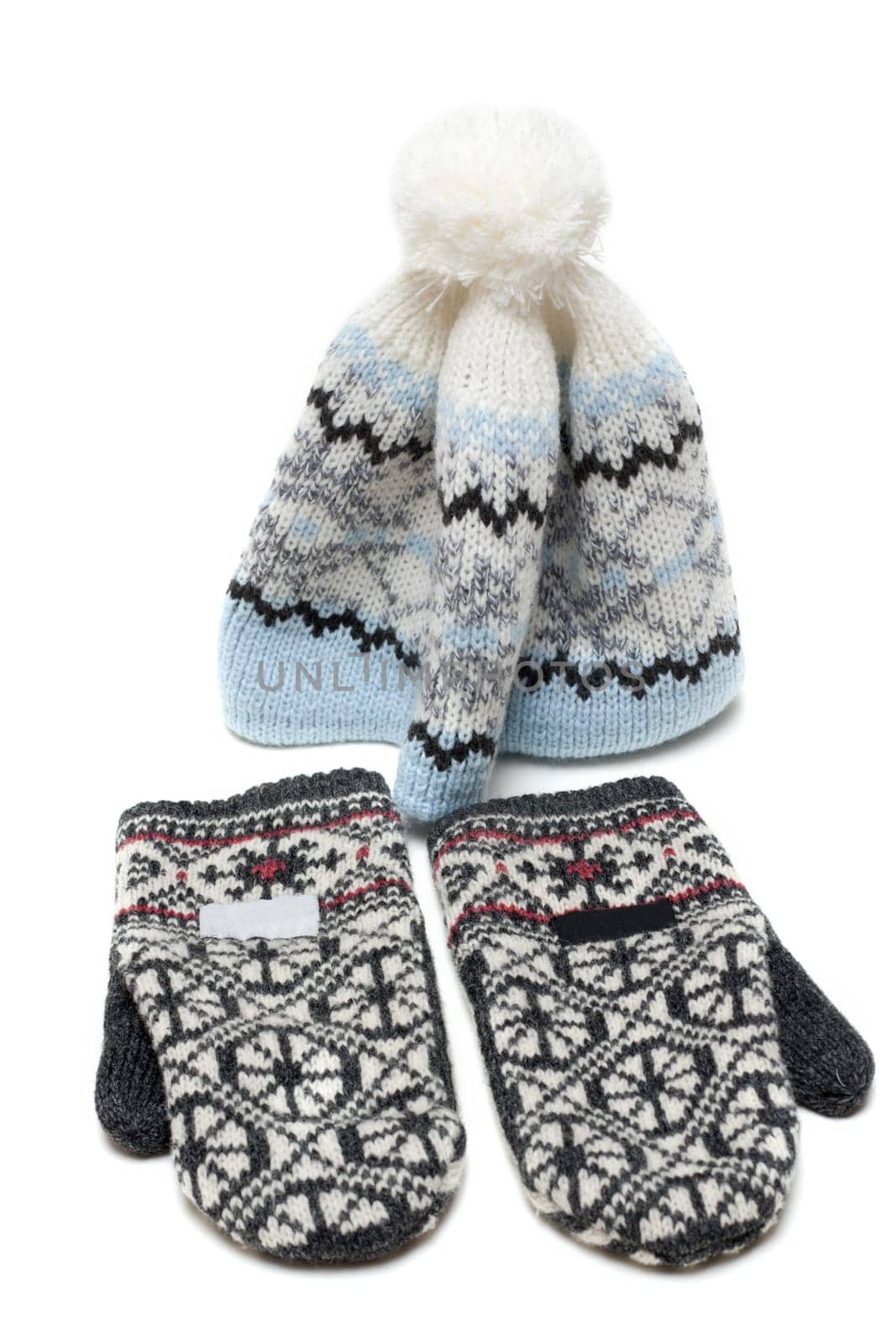 Knitted mittens and nodding on white background