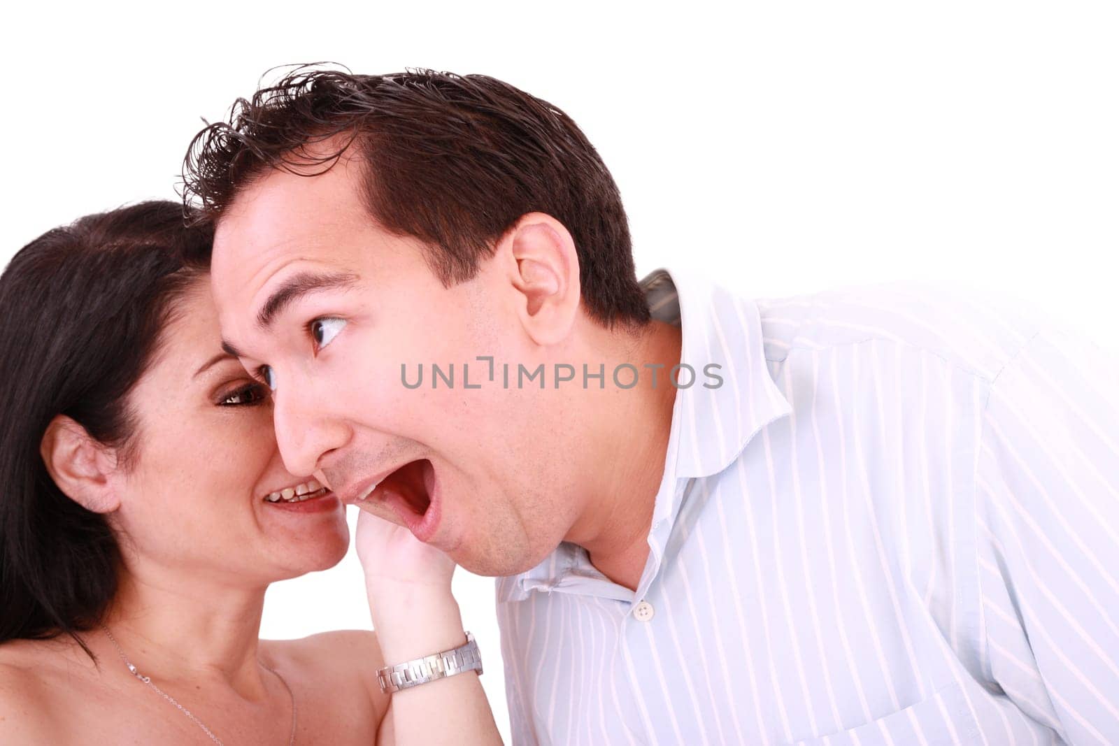 girl tells something into surprised guy&#039 s ear isolated on white background
