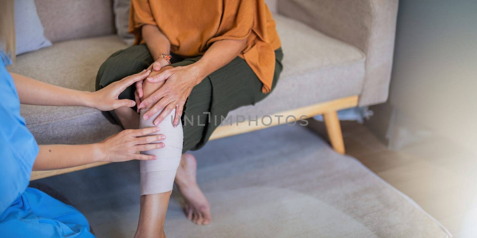 Physical therapist caregiver Asian and Caucasian senior women trust moving hand in rehabilitation. Physiotherapy healthcare, Medical caregiver consulting disabled elderly patient at home.