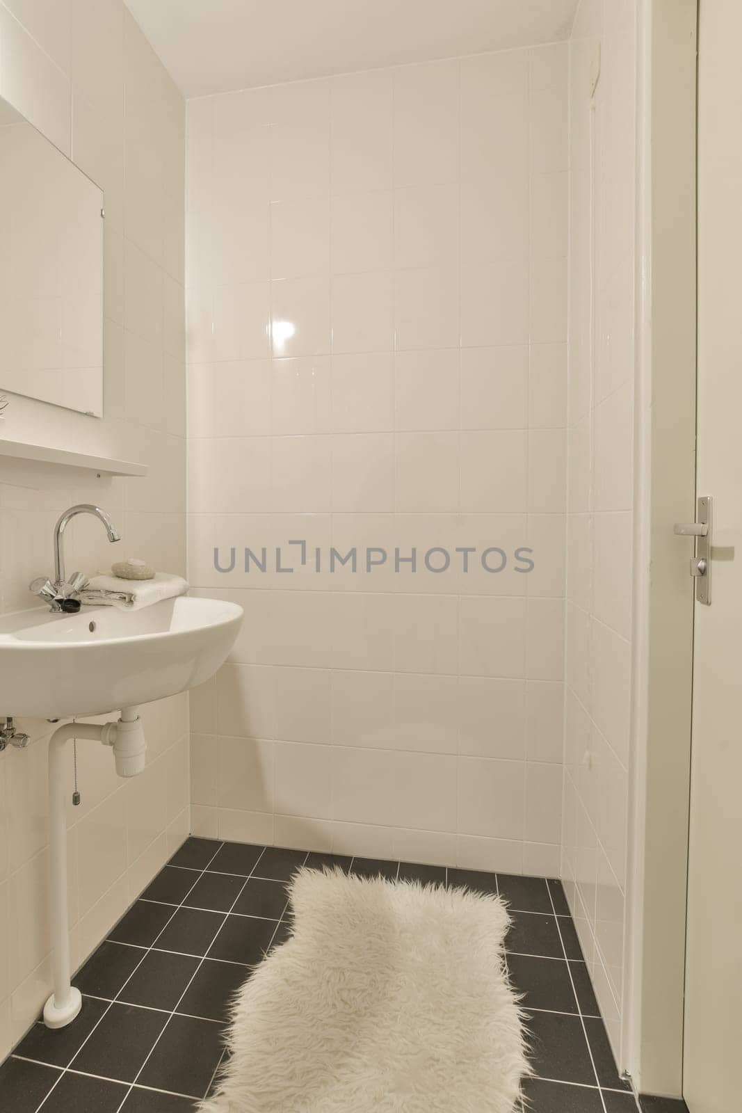 a small bathroom with a sink and a white rug by casamedia