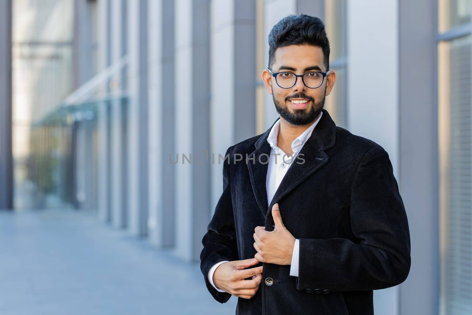 Portrait of happy Indian businessman smiling friendly, glad expression looking at camera, feel satisfied good news outdoors. Arabian Hindu freelancer in downtown city street. Business people lifestyle