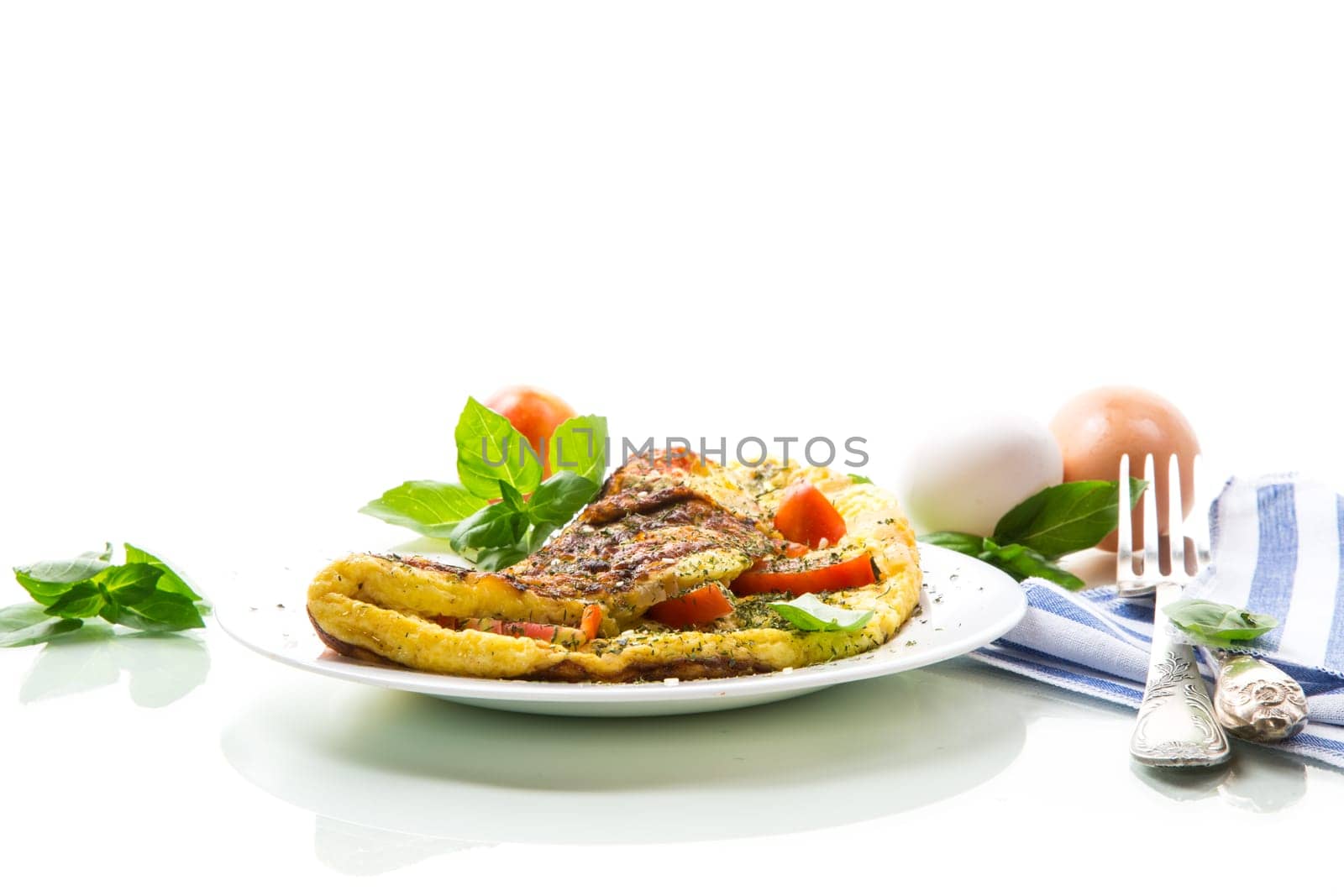 Stuffed omelette with tomatoes isolated on white background. Healthy diet food for breakfast.