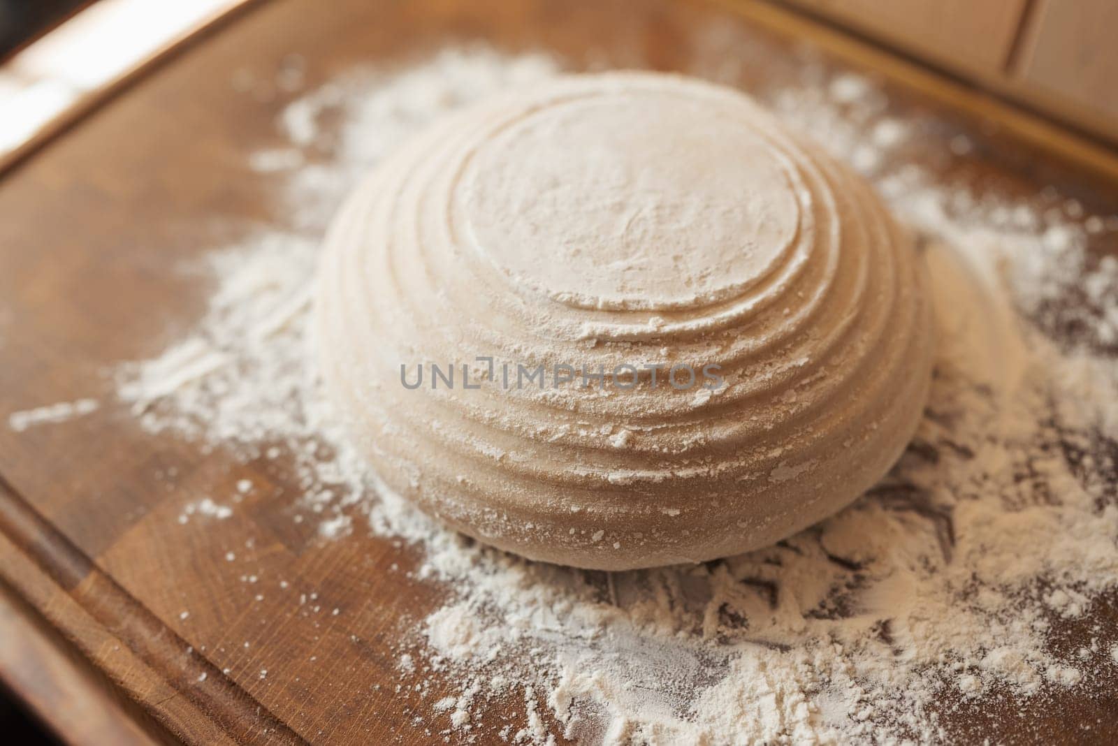 Dough in round form of future bread on cutting board, powdered with flour by VitaliiPetrushenko