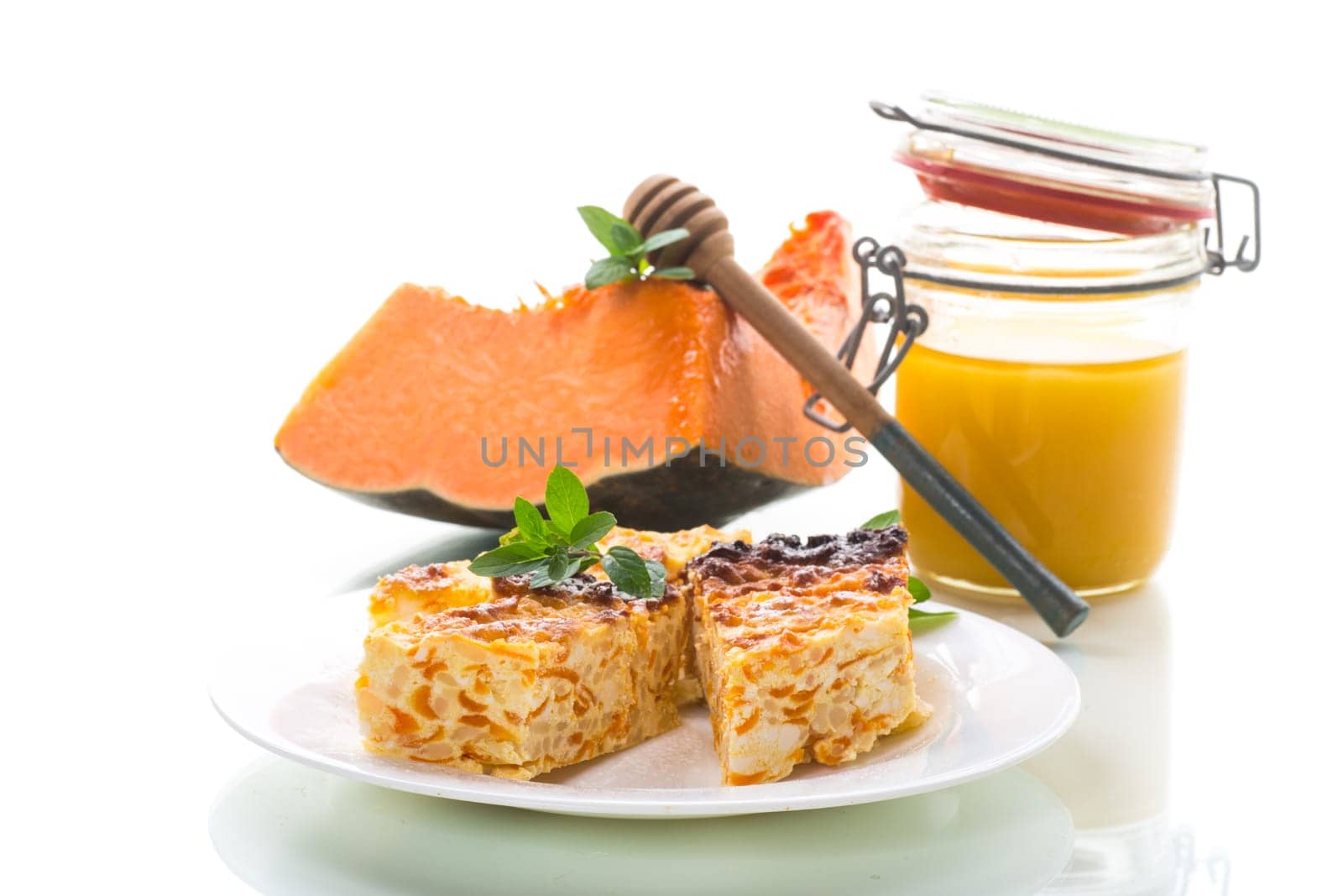 Cooked cottage cheese casserole with pieces of pumpkin inside, isolated on white background.
