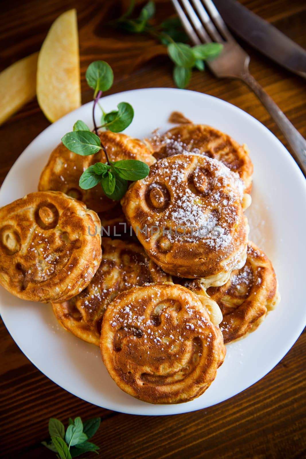 Cooked fried round pancakes with quince filling, cute pancakes with a smile, autumn recipes, on a wooden table