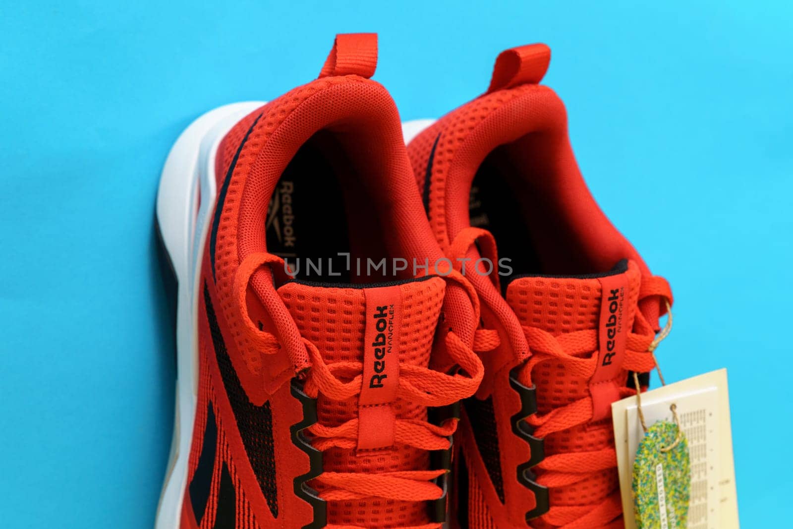 Tyumen, Russia-August 03, 2023: Modern red Reebok sneakers on blue background. Nanoflex TR V2.