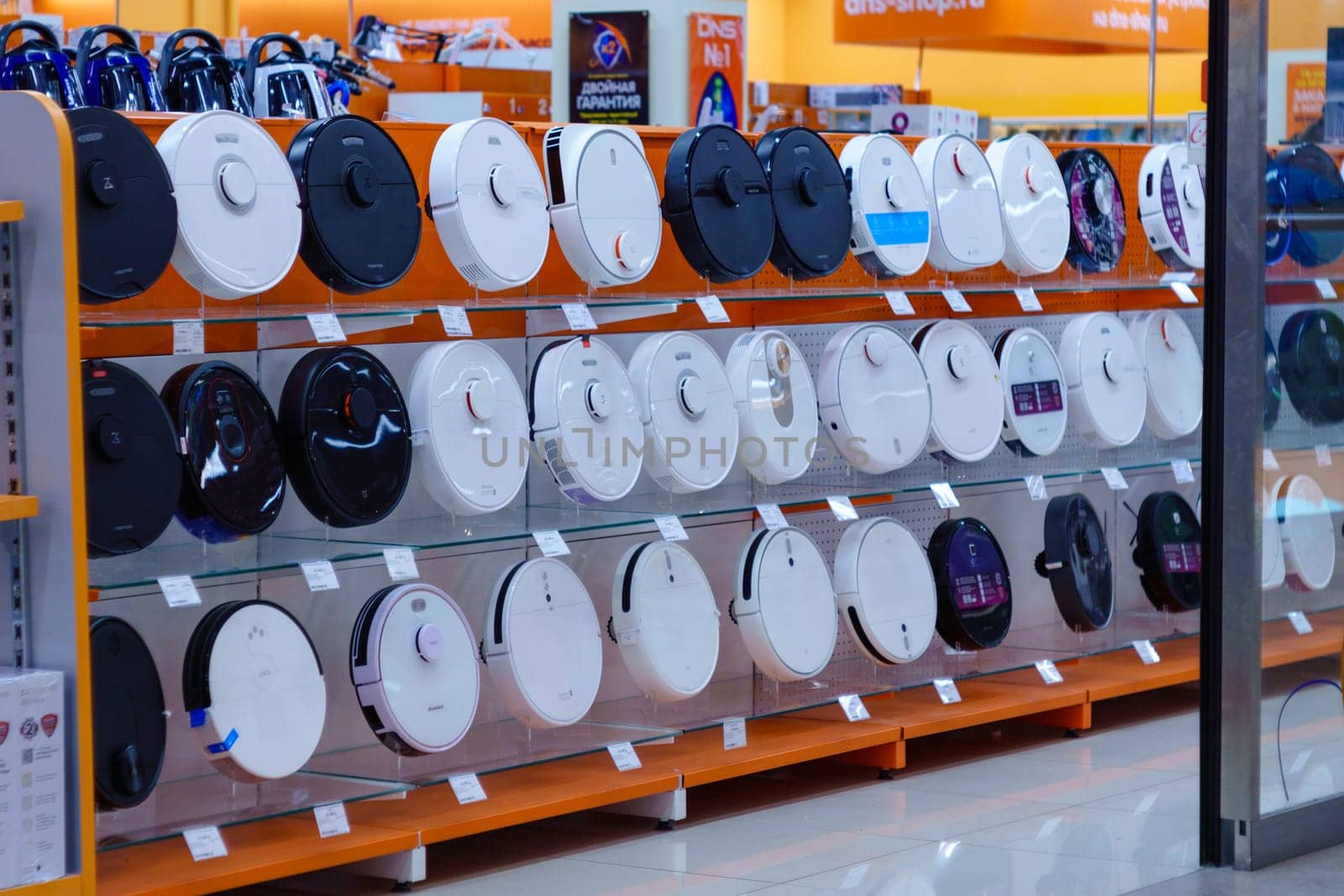 Tyumen, Russia-August 09, 2023: Shelves with robot vacuum cleaners on the windows of the hypermarket. Selective focus. Sale of household appliances