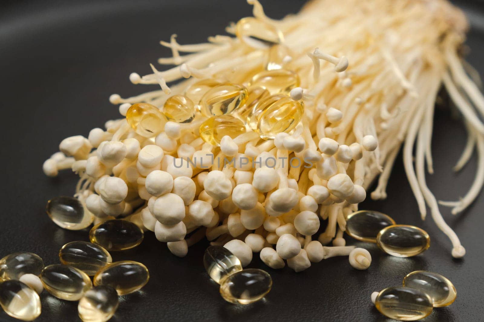 Mushroom or enoki close up, enokitake Flammulina velutipes. Capsules, dietary supplements.