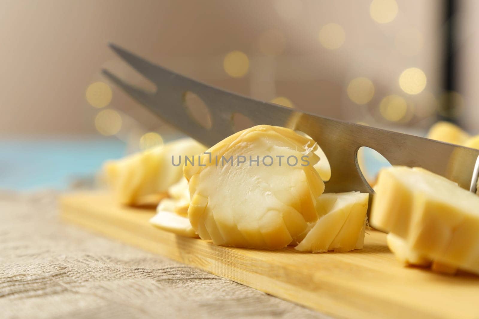 Cuts cheese in close-up with a cheese knife. Selective focus by darksoul72