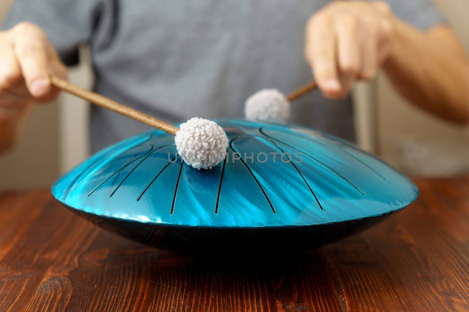 Glucophone and drum sticks on the lap man playing on instrument, drum for meditation and mental health