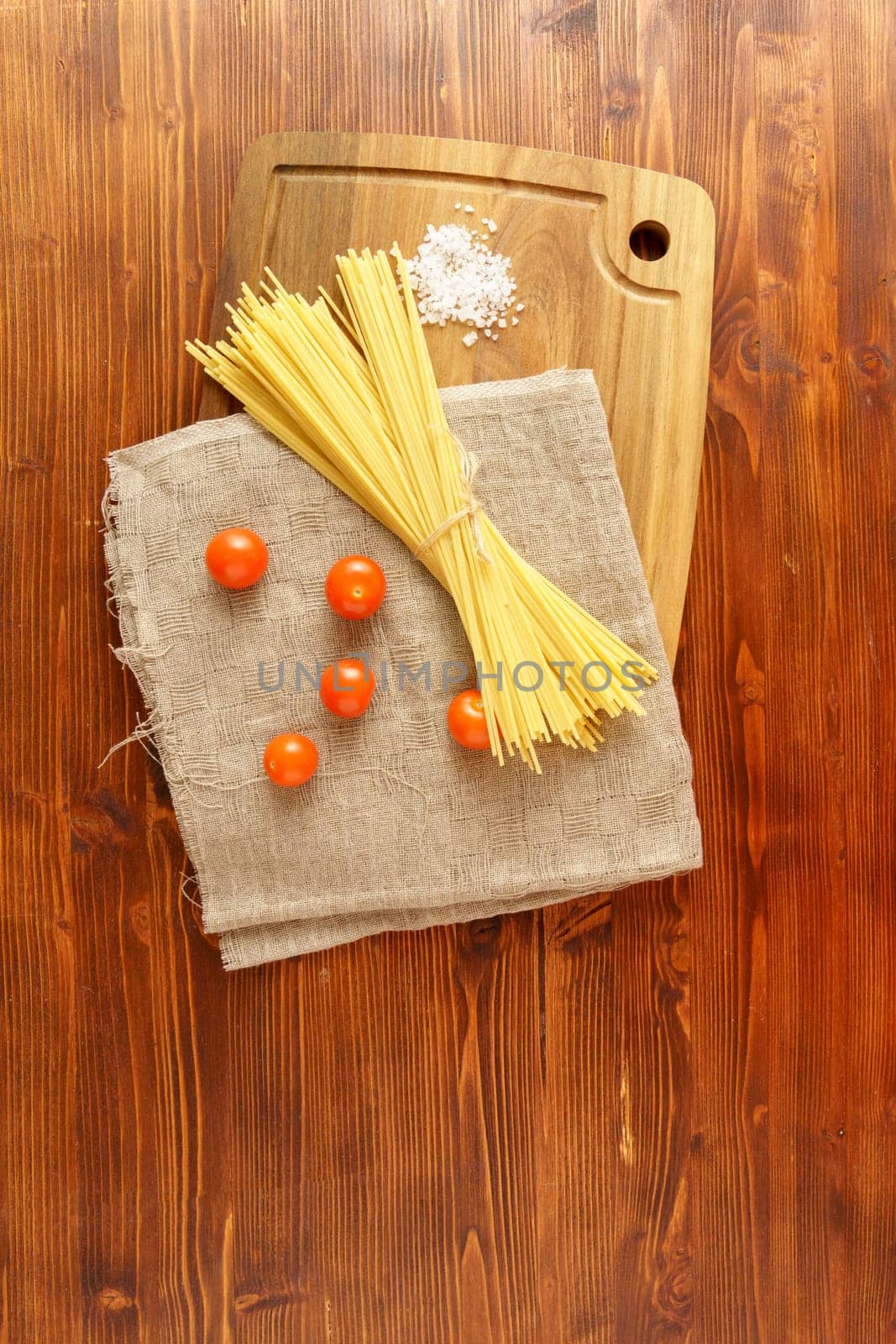Spaghetti on a rustic background. Yellow Italian pasta. Long spaghetti. Raw spaghetti. Vertical photo