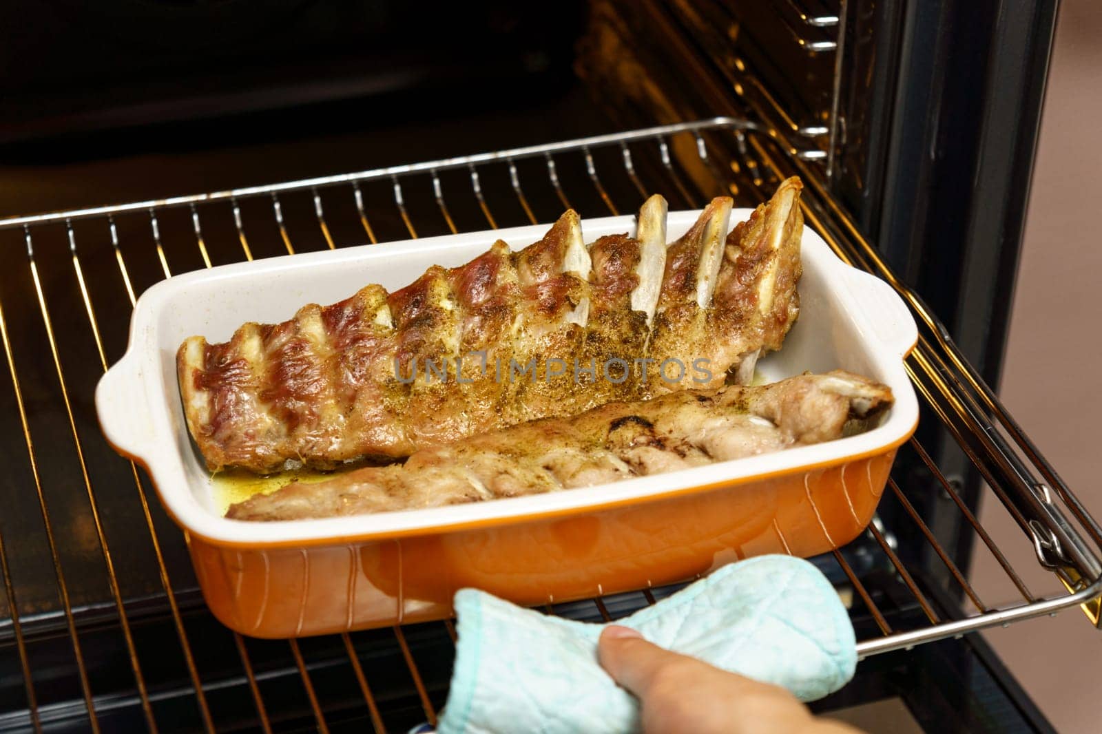 Takes pork ribs out of the oven, cooking homemade food. Selective focus by darksoul72