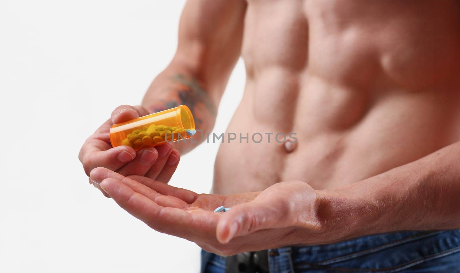 Fitness man pours pills from the jar into hand intake of hormonal preparations for rapid growth. Of doping muscles to achieve high results is experiencing problems with potency after closeup concept.