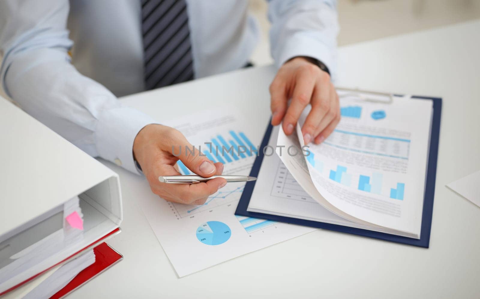Male hands hold documents with financial statistics at office workspace closeup. White collar check money papers stock exchange market internal Revenue Service inspector earning list concept
