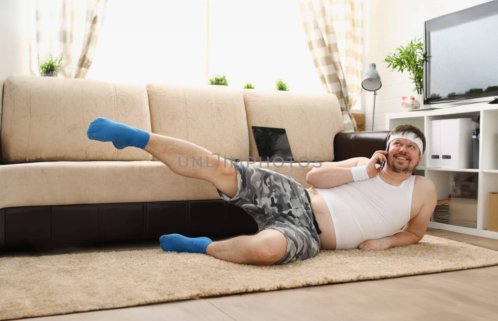 Young handsome fitness man lies on fat mat with by kuprevich