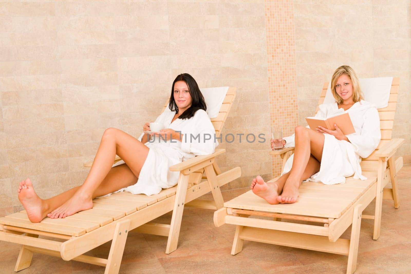 Spa luxury relax room two beautiful women lying on sun-beds