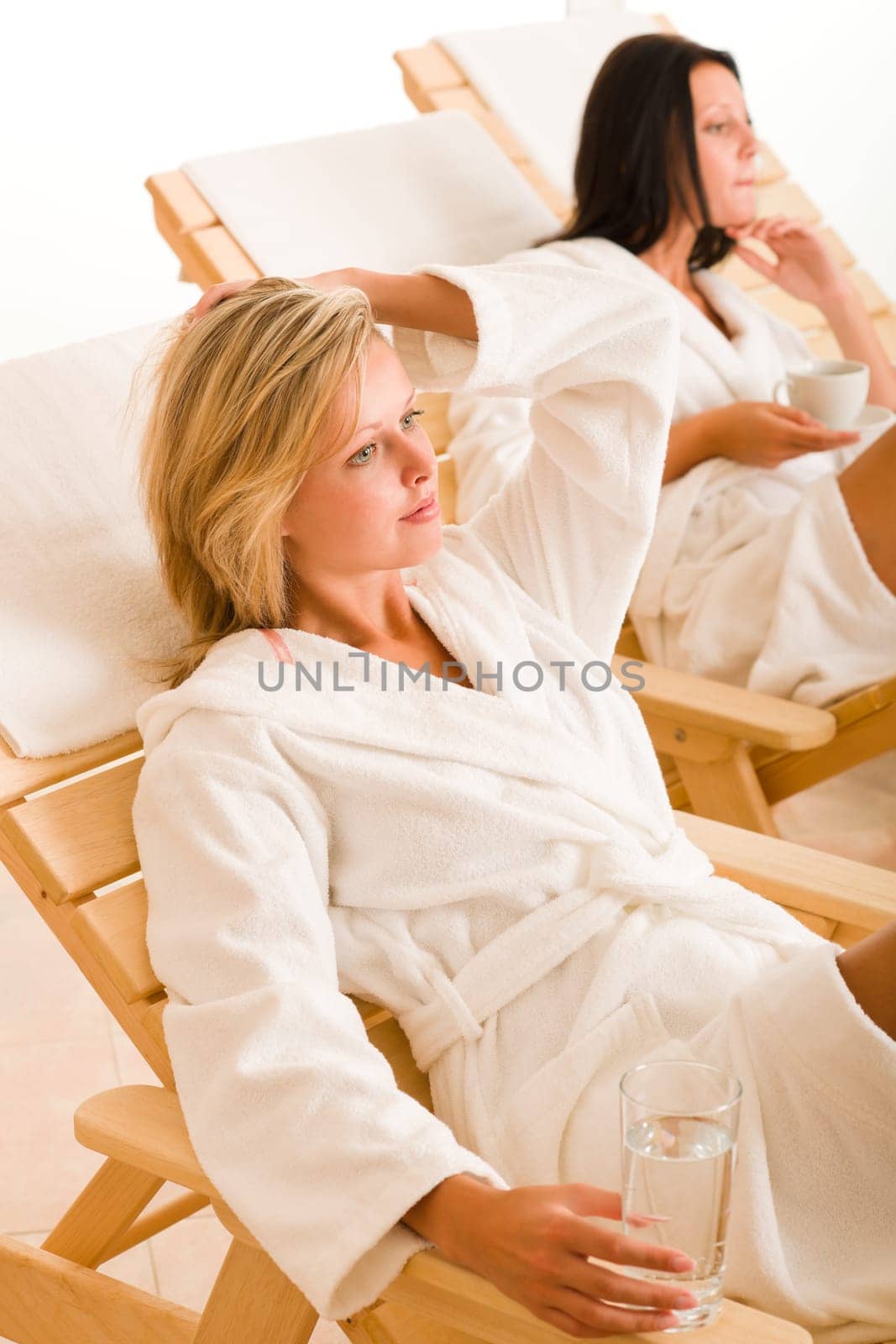 Relax luxury spa beauty women enjoy refreshments lying on sun-beds