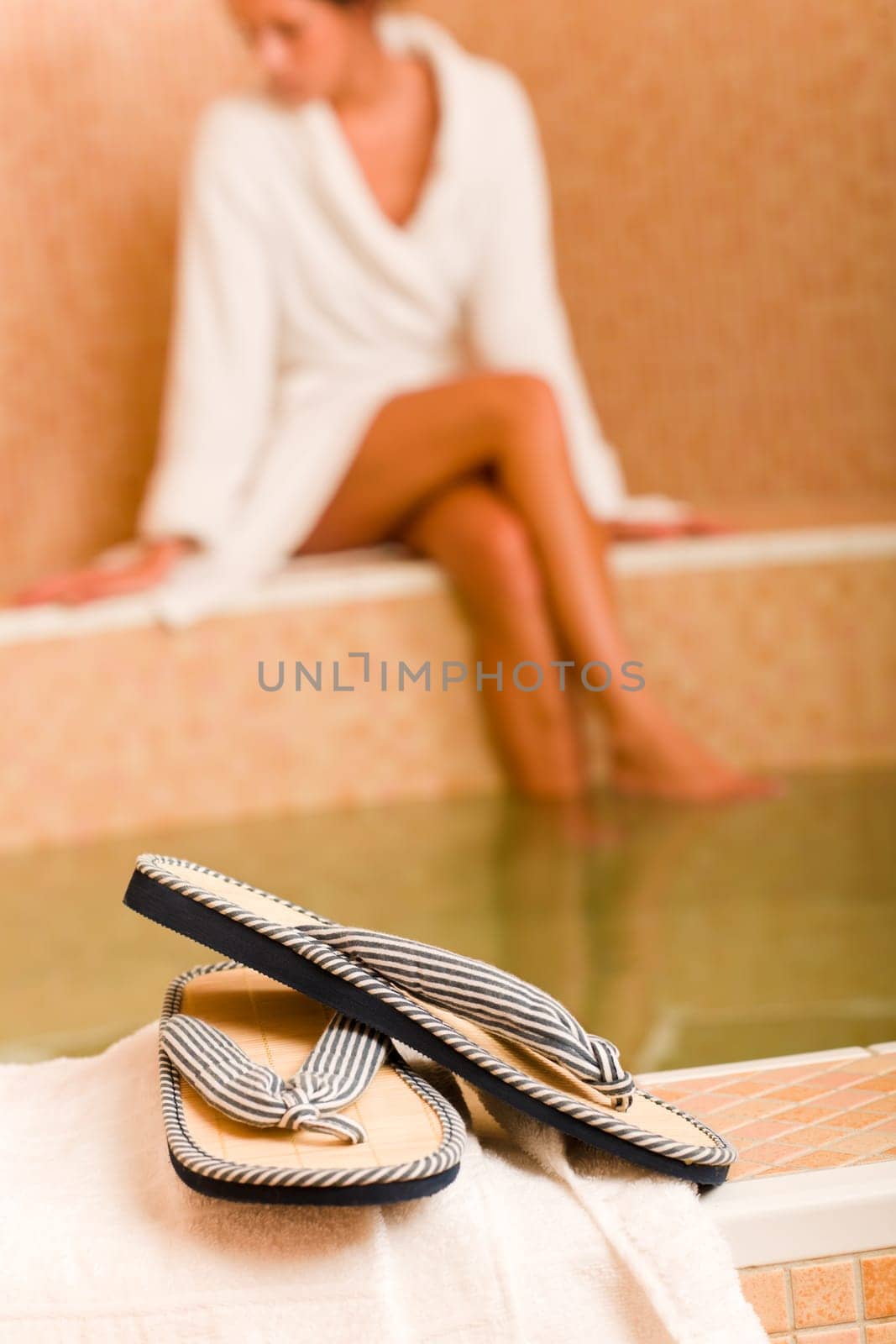 Flip-flops close-up relax spa pool woman wear bathrobe