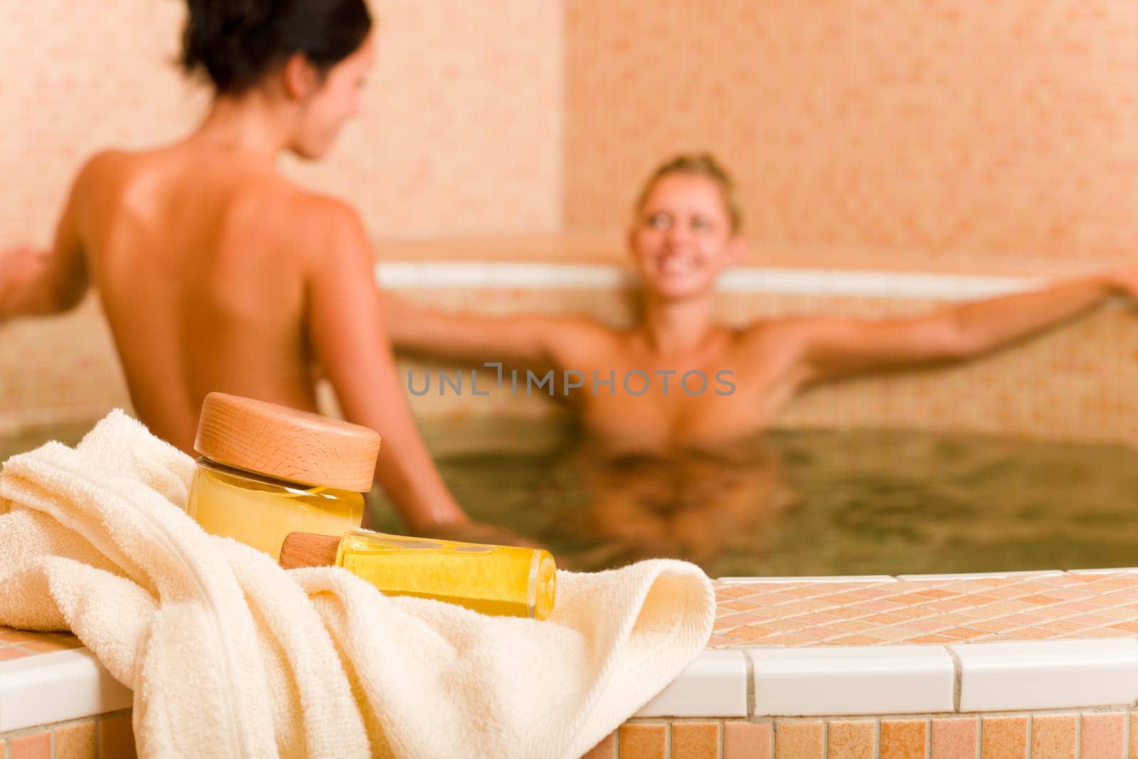 Spa and beauty products two naked women inside pool water beauty health