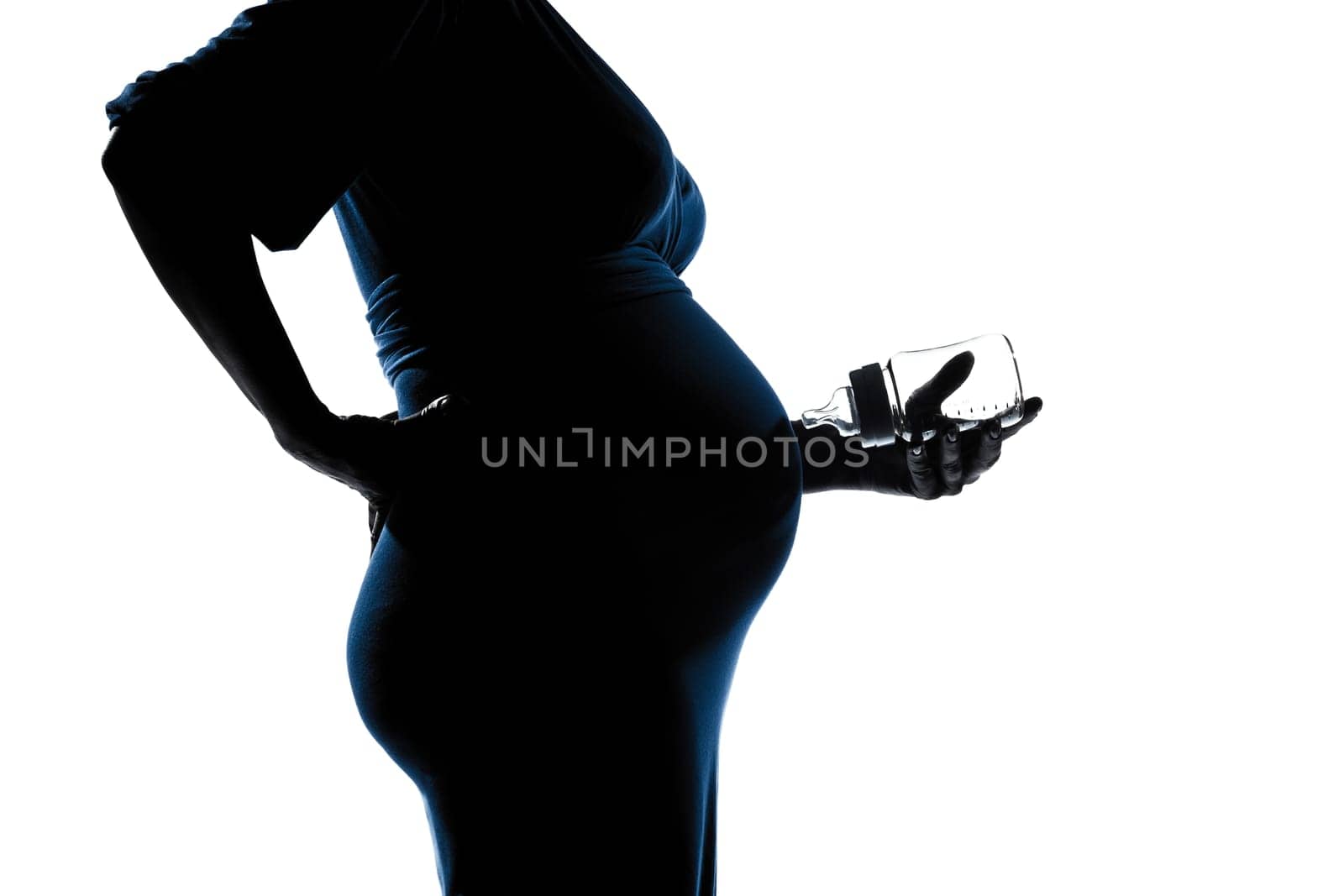 beautiful caucasian pregnant woman holding baby bottle in silhouette on studio isolated white background