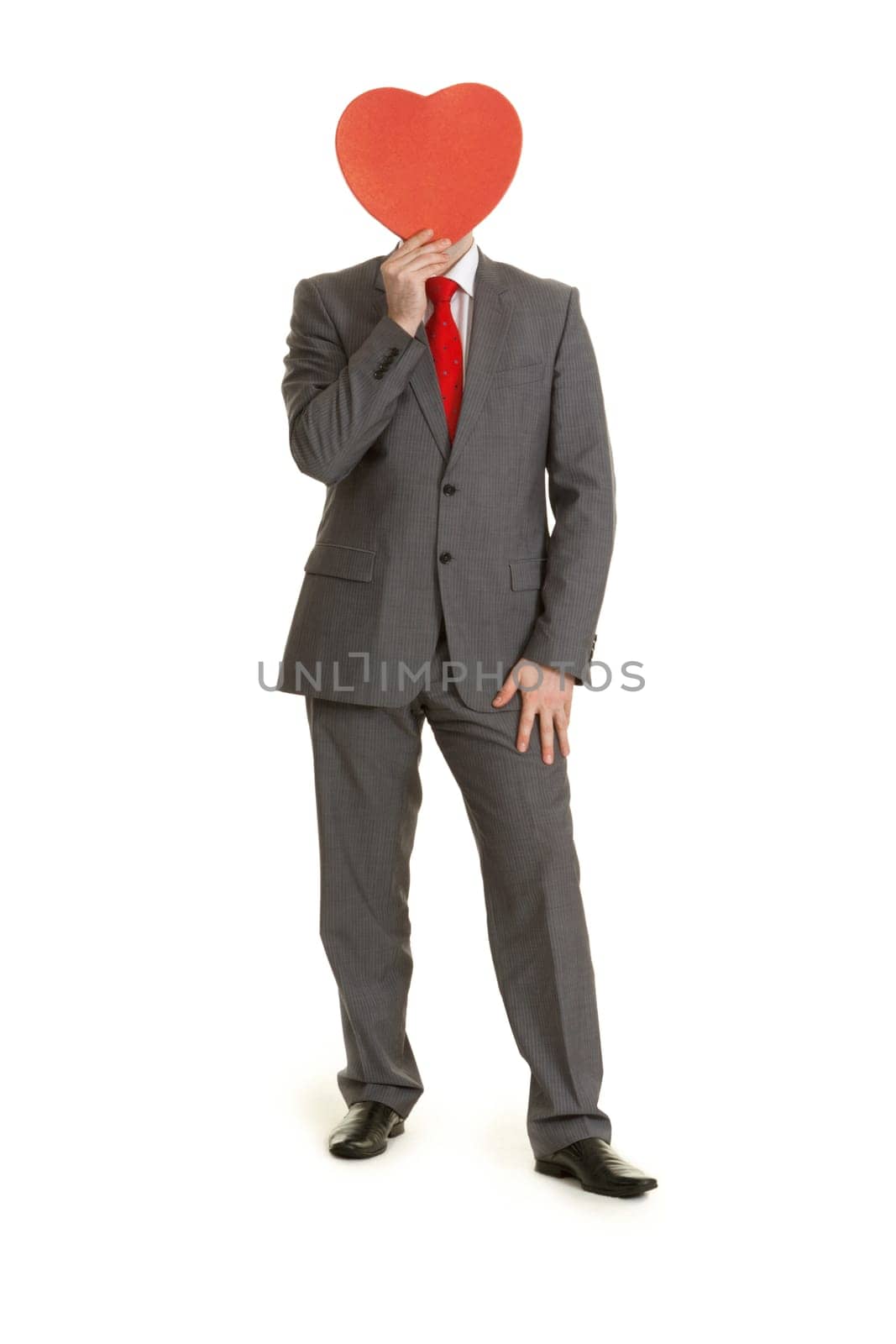Man in gray suit and tie keeps in hand decorative red heart