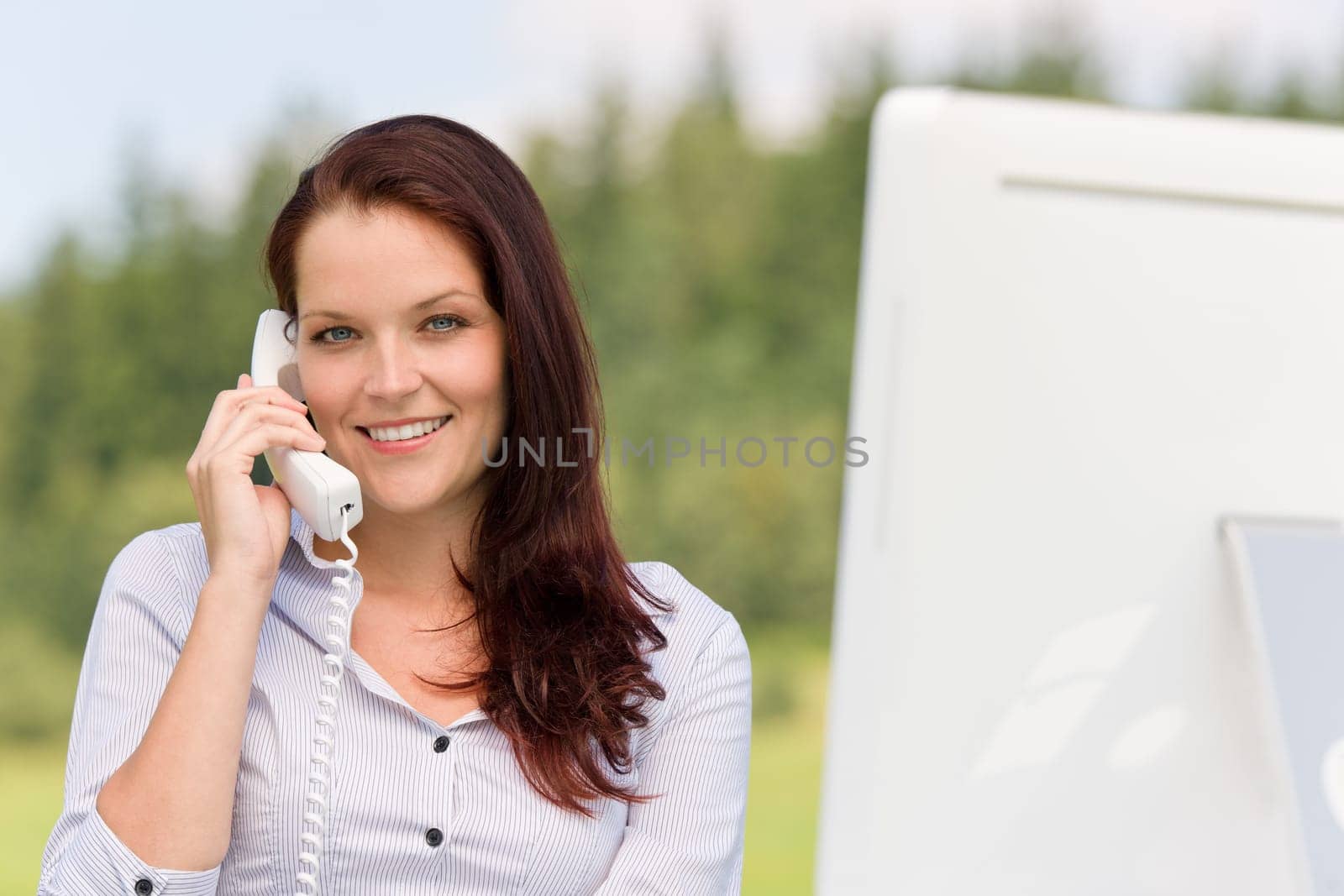Young businesswoman in nature attractive smiling calling sitting behind table
