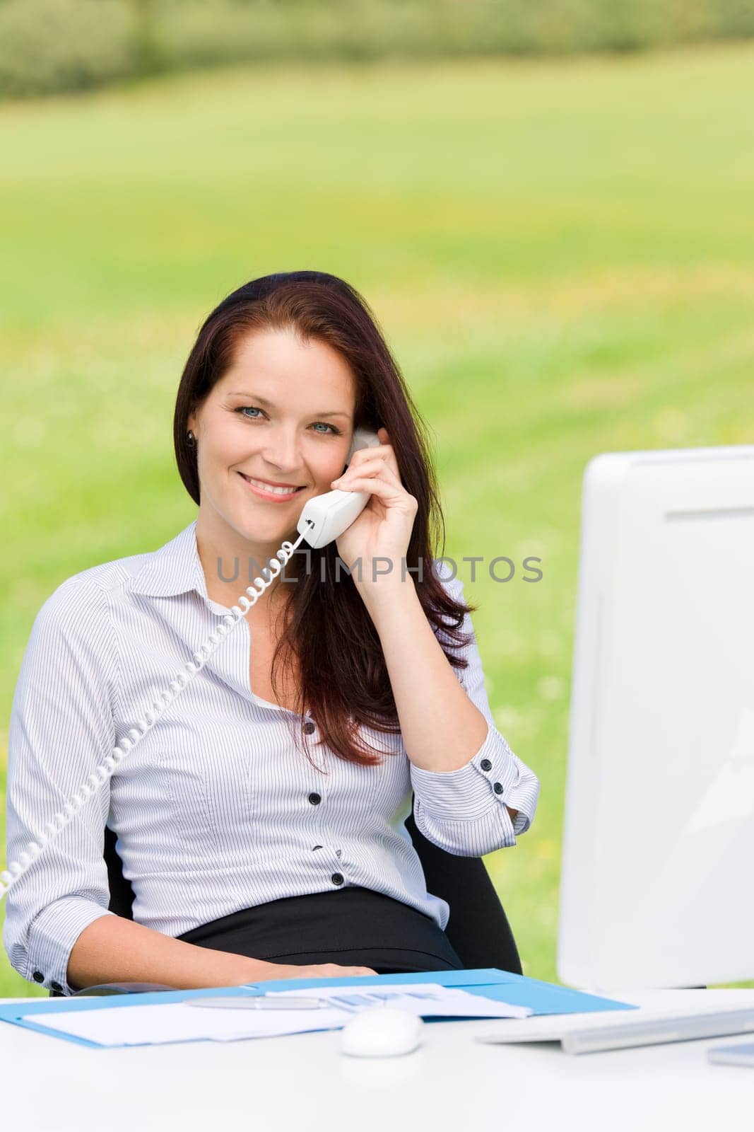 Young businesswoman in nature attractive smiling calling sitting behind table