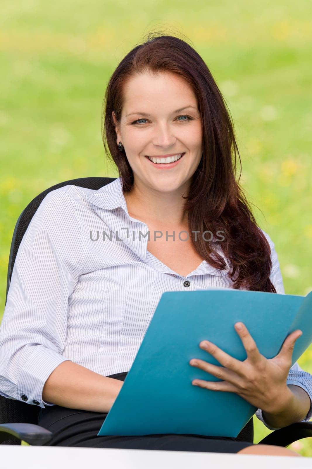 Young businesswoman in nature attractive smiling holding folder behind table