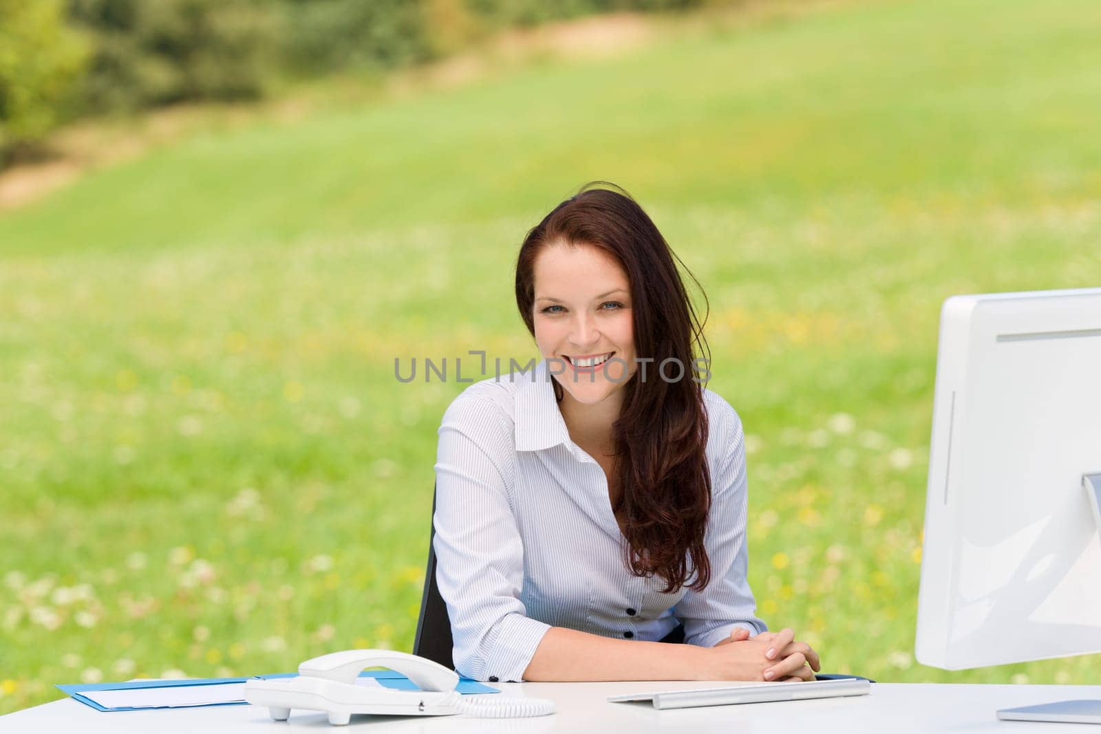 Young businesswoman in nature attractive smiling sitting behind computer table