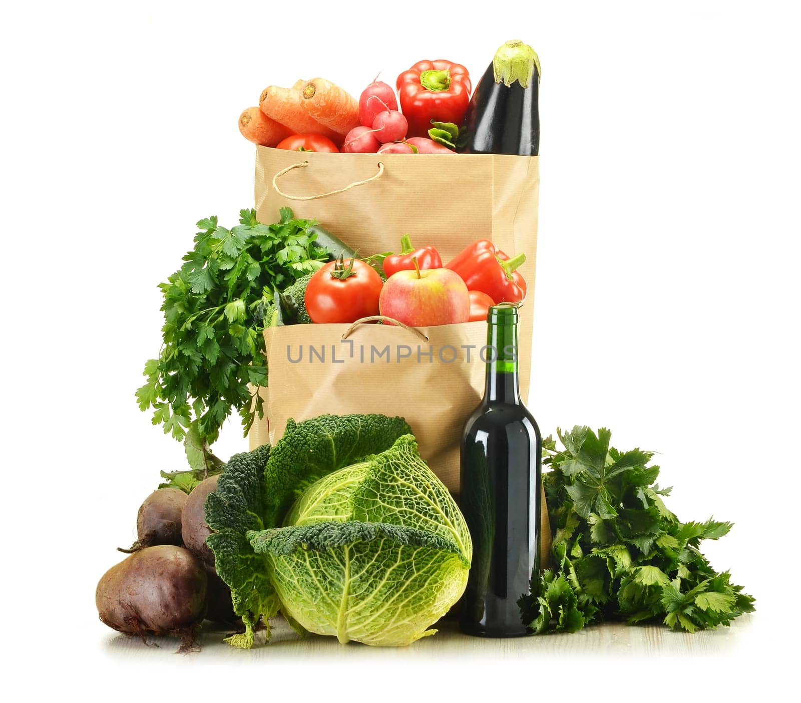 Composition with raw vegetables and shopping bag isolated on white