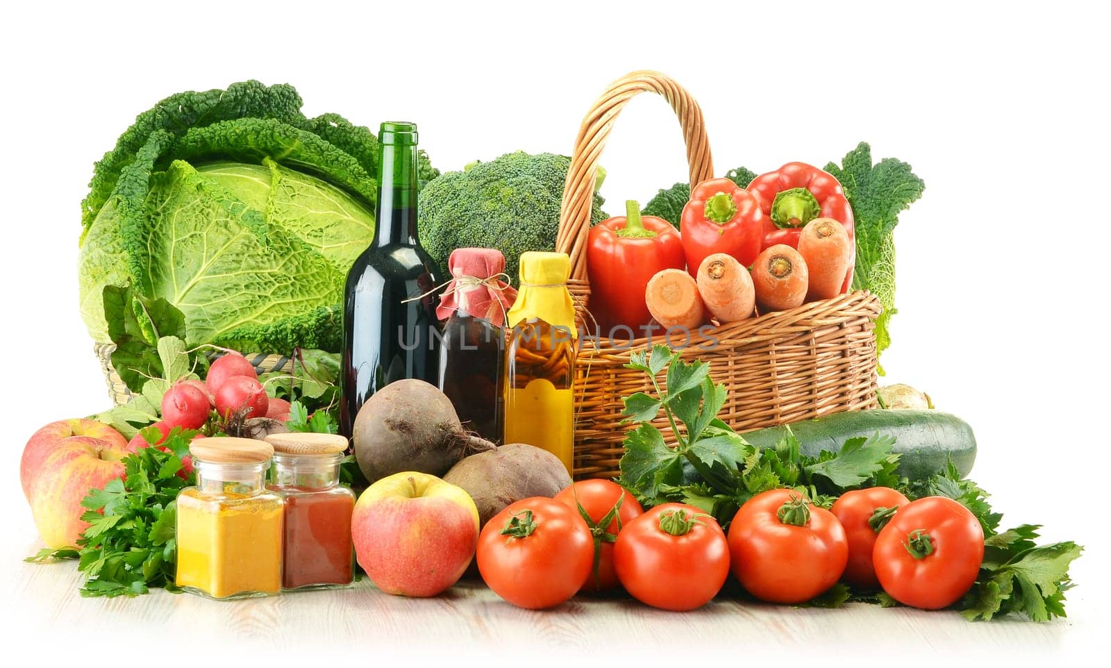 Composition with raw vegetables and wicker basket isolated on white