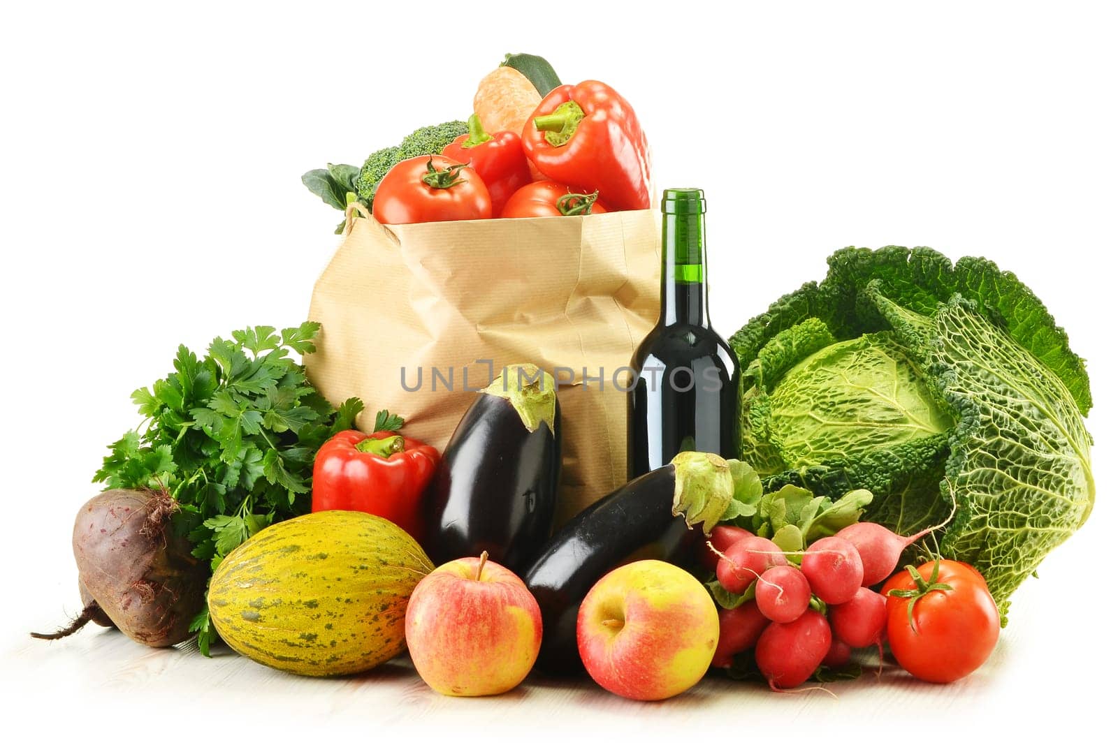 Composition with raw vegetables and shopping bag isolated on white