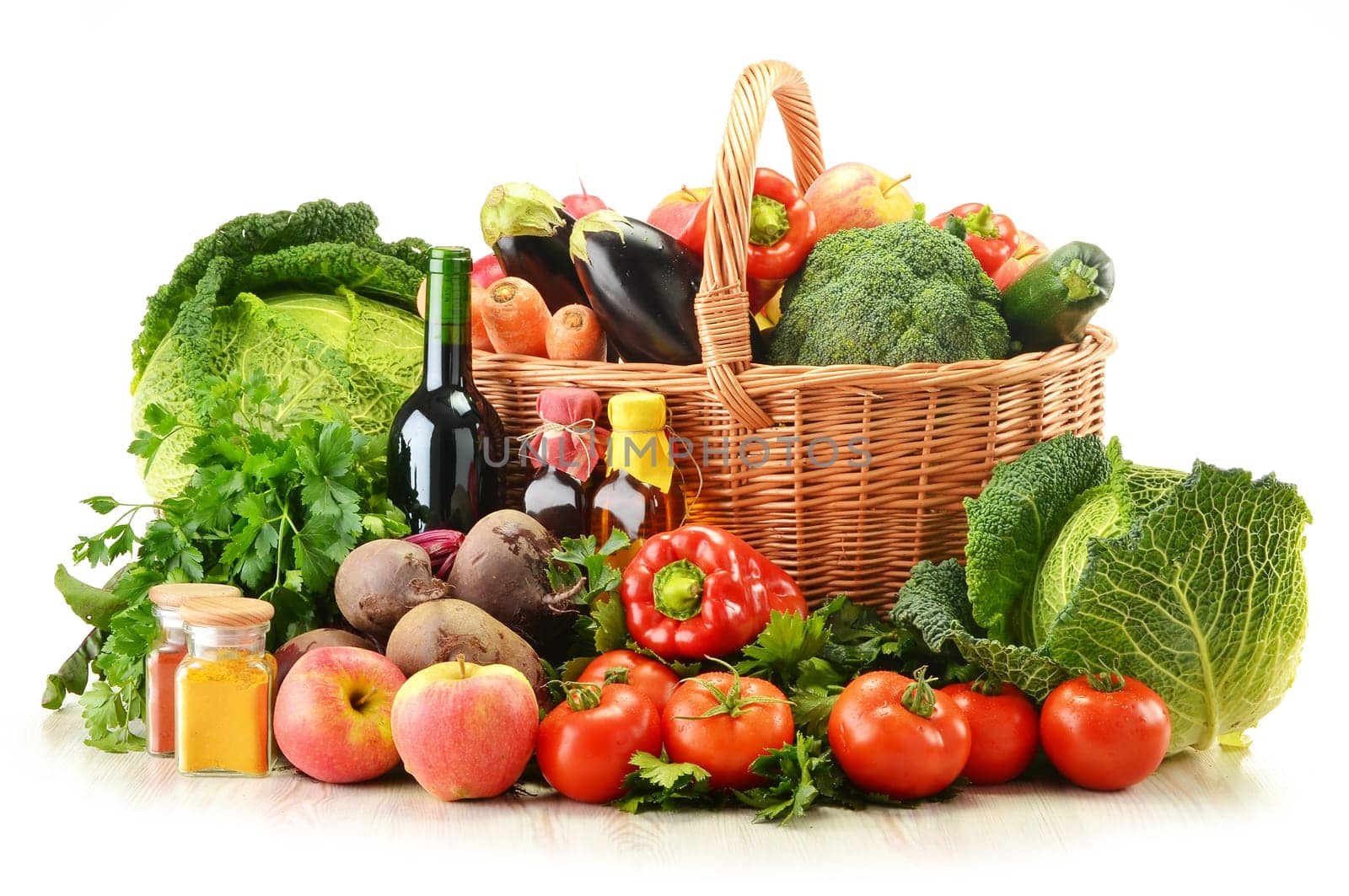 Composition with raw vegetables and wicker basket isolated on white