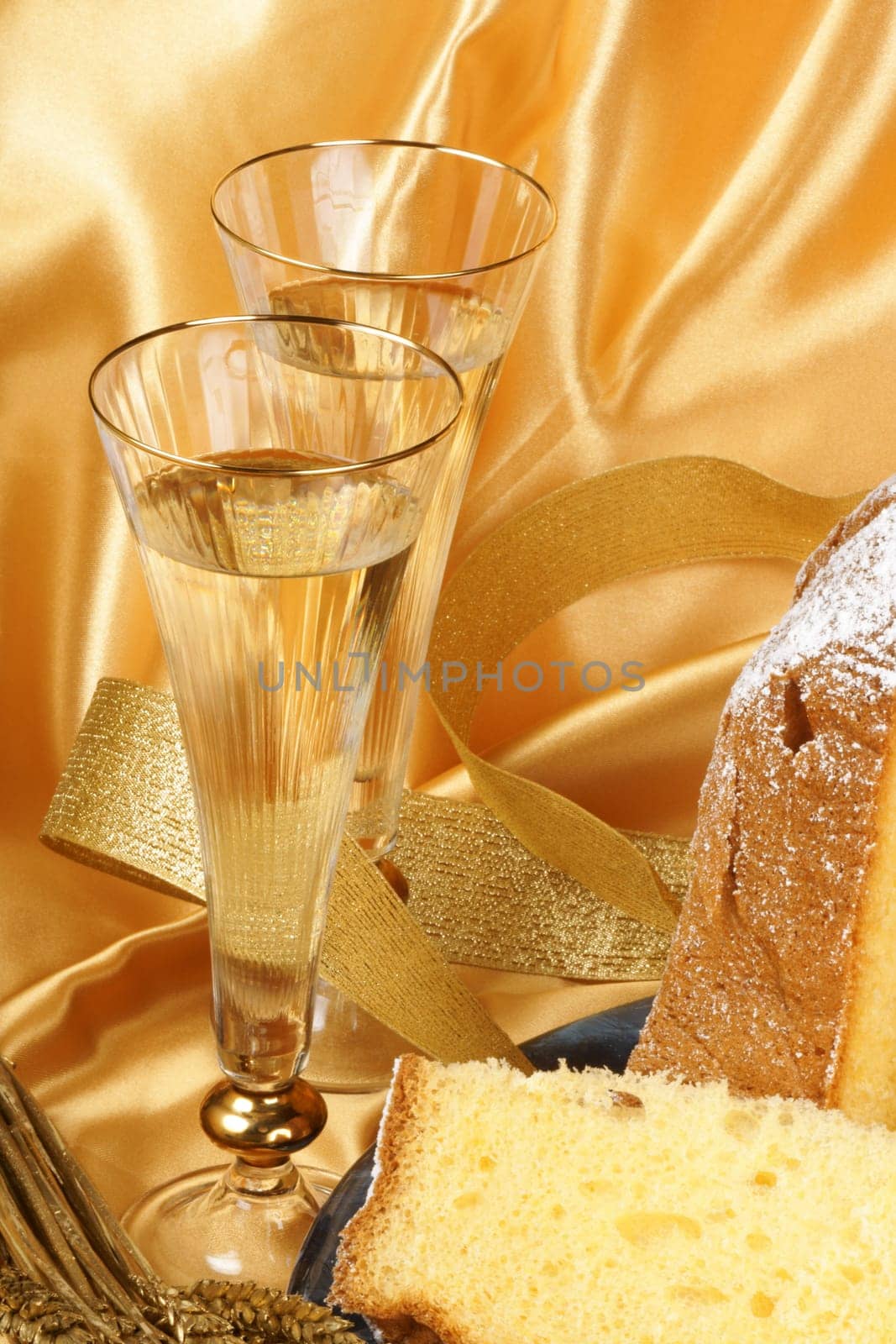Christmas composition with Pandoro the golden cake of Verona, two glasses of spumante and some ornaments over a yellow background