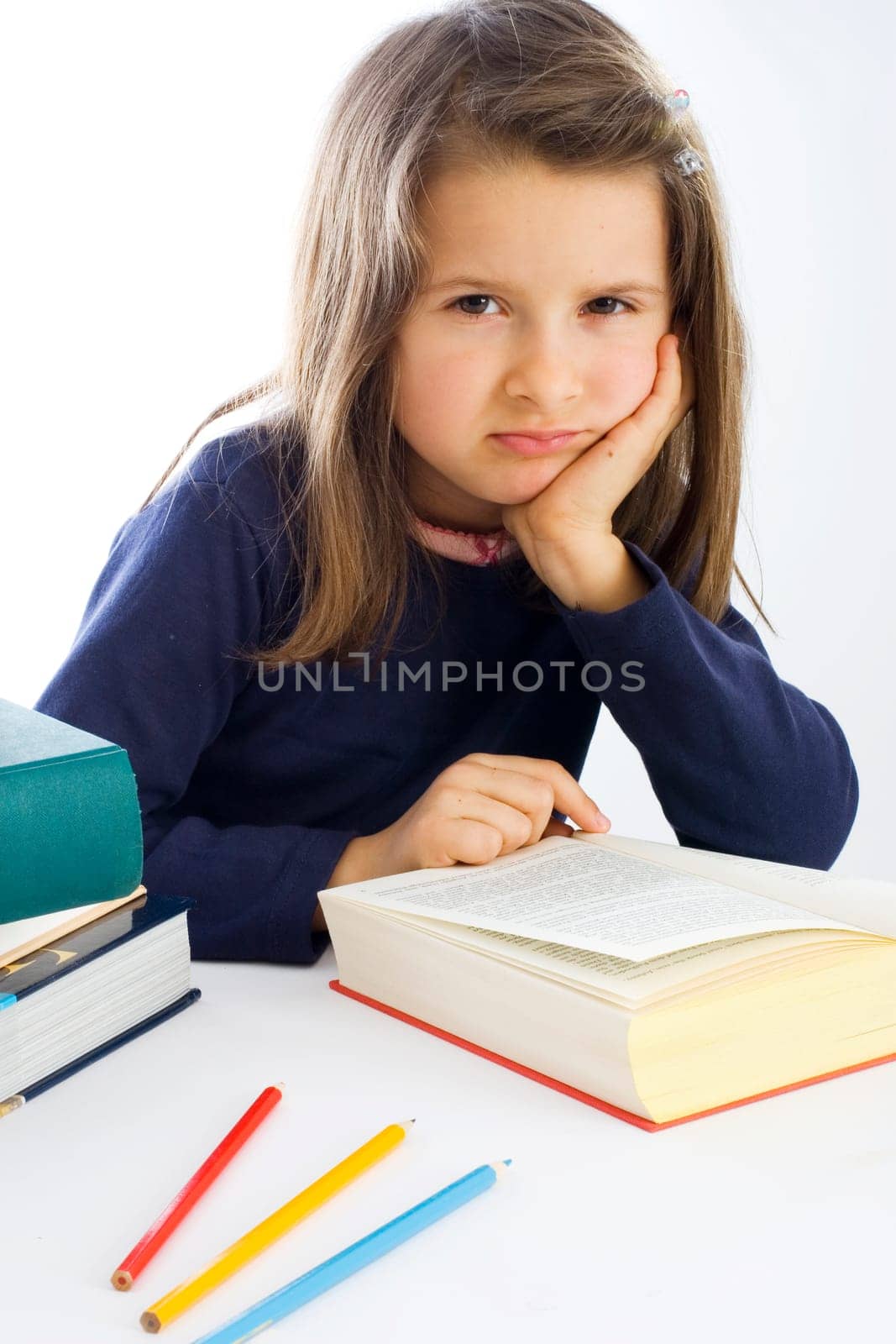 six-year-old girl sits listlessly in front of a book (mr)